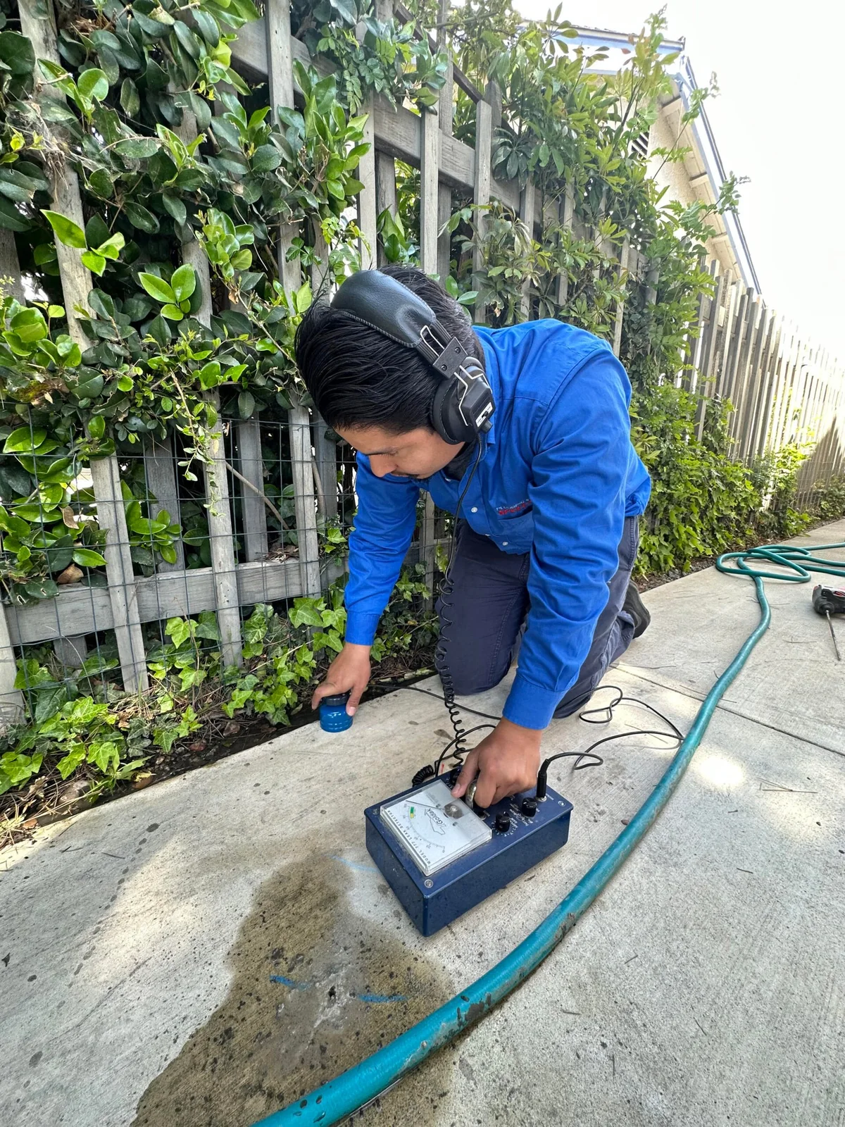 Technician inspecting an outdoor plumbing line