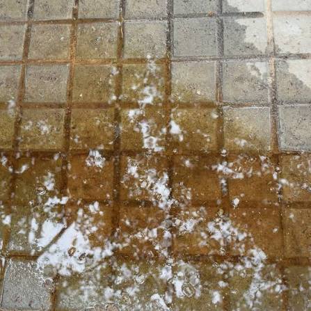 Water pooling across floor tiles as a possible leak warning sign